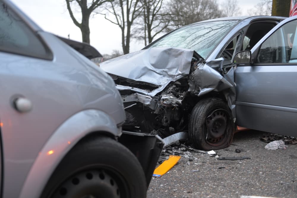 Two heavily damaged cars after a collision highlight common accident scenarios in Palo Alto intersections.
