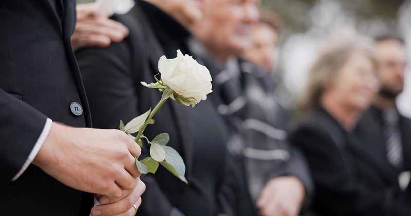 Family members at a funeral for the loss of a loved one due to wrongful death.