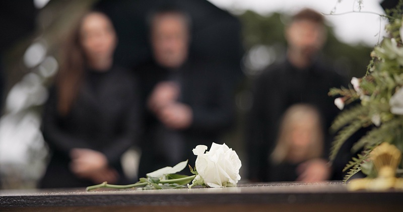 Rose, coffin and funeral at cemetery outdoor at burial ceremony of family together at grave. Death,.
